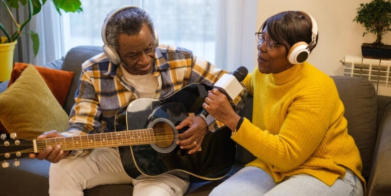 Elderly Couple Singing With Guitar and Headphones in Assisted Living