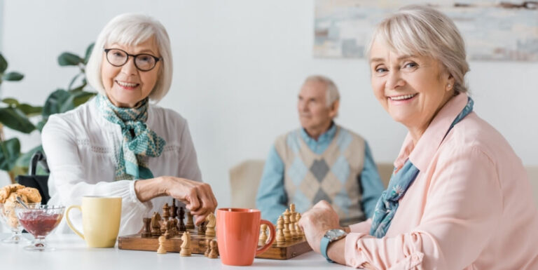 Two Elderly Women Playing Chess Together at an Assisted Living Facility