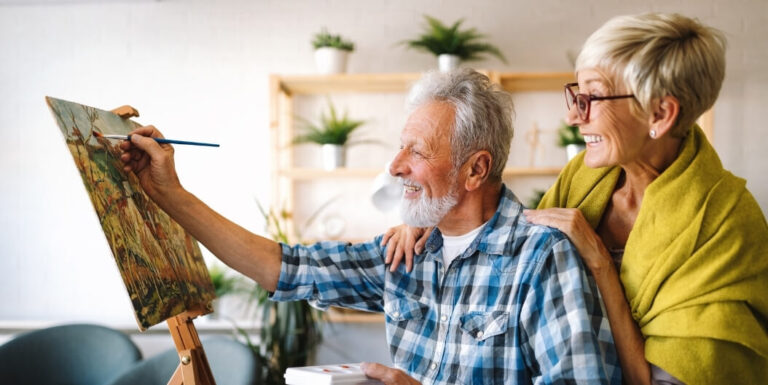 Elderly Couple Painting on a Canvas Together at a Memory Care Facility