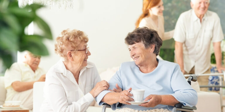 Elderly Women Sharing Coffee and Conversation at Assisted Living Facility