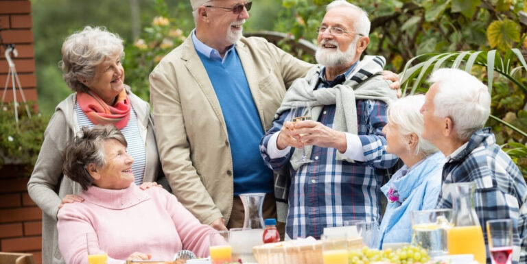 Elderly Friends Toasting Drinks Together at Memory Care Facility
